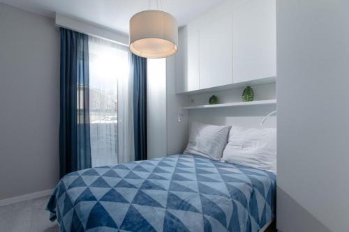una camera con un letto blu e bianco e una finestra di Fale i Klify a Rewal