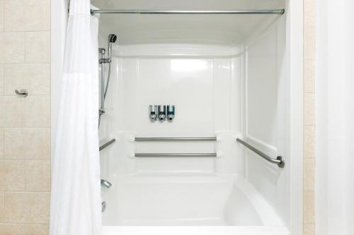 a bathroom with a shower with a white shower curtain at Gravity Haus Truckee-Tahoe in Truckee