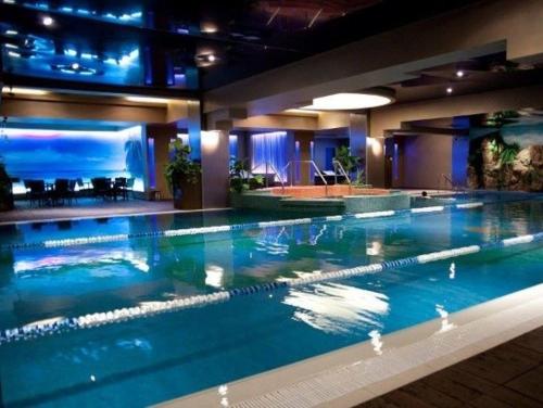 a large swimming pool in a hotel room at Cataleya Suites Aparthotel in Bucharest