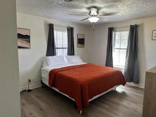 una camera con letto e ventilatore a soffitto di Spacious 5 bedroom home in Bridge City a Bridge City