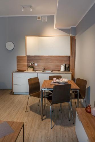 a kitchen and dining room with a table and chairs at Sunset A23 przy plaży in Pobierowo
