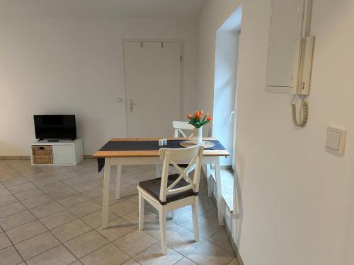 cocina con mesa y sillas y TV en Apartment Gästehaus Tönisvorst en Tönisvorst