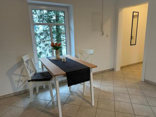 una sala da pranzo con tavolo, sedie e finestra di Apartment Gästehaus Tönisvorst a Tönisvorst