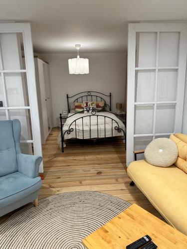 a bedroom with a bed and a chair and a rug at Apartament Zatorze in Olsztyn