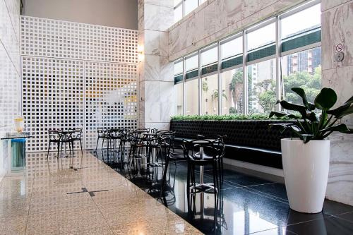 a restaurant with tables and chairs and a large window at GS Properties - Hotel Líder in Brasilia