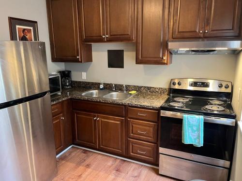 a kitchen with wooden cabinets and a stainless steel refrigerator at Carter #3 Two bedroom unit near Xavier Downtown in Cincinnati