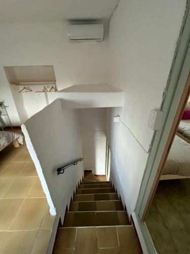 a staircase in a room with white walls and brown floors at La Casilla in Montilla