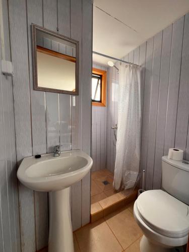 a bathroom with a white sink and a toilet at Hostal B&B Coastal Natales in Puerto Natales
