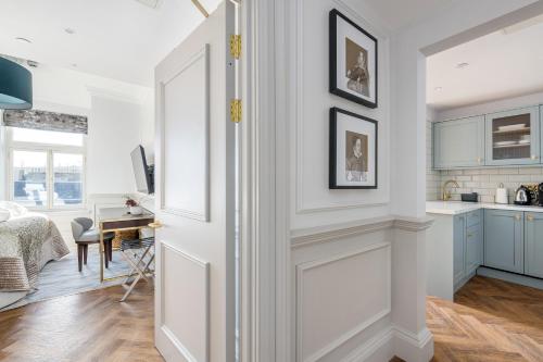 a kitchen and living room with white walls and a desk at RÌGH Residences - George Street in Edinburgh