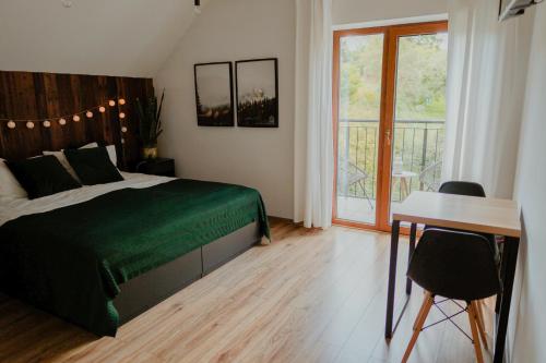 a bedroom with a bed and a desk and a window at Zacisze in Morawica