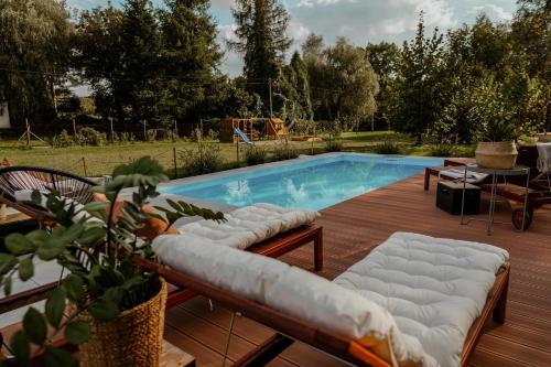 a swimming pool with a wooden deck with at Zacisze in Morawica