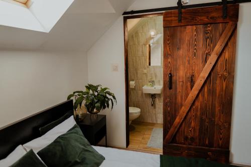 a bedroom with a wooden door and a bathroom at Zacisze in Morawica