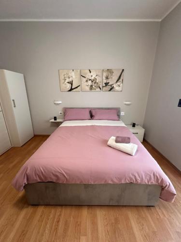een slaapkamer met een roze bed en 2 handdoeken bij Il campanile in Scafati