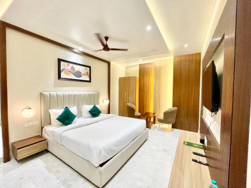 バラナシにあるHOTEL VEDANGAM INN ! VARANASI - Forɘigner's Choice ! fully Air-Conditioned hotel with Parking availability, near Kashi Vishwanath Temple, and Ganga ghatのベッドとテレビが備わるホテルルームです。