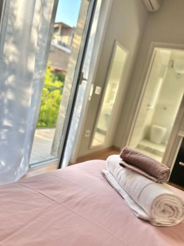 a bed with two towels and a window at Il campanile in Scafati