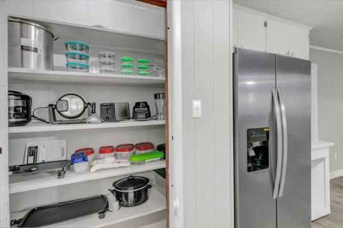 a kitchen with a stainless steel refrigerator and shelves at Stylish 4 bedroom home in Groves in Groves