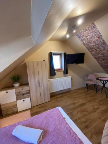 a attic room with a bed and a table at Centrum Vendégház in Tihany