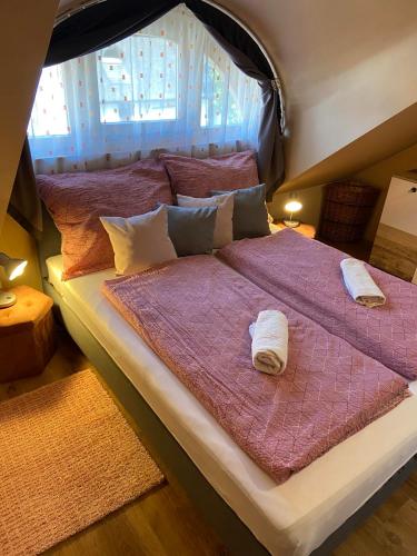 a large bed with two towels on top of it at Centrum Vendégház in Tihany