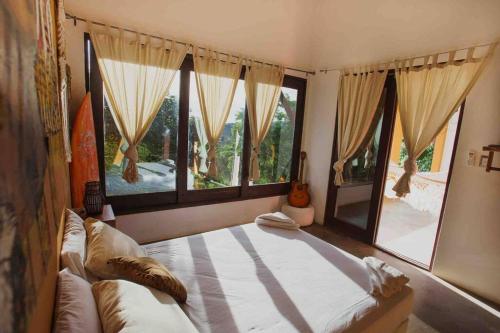 1 dormitorio con 1 cama grande y ventanas grandes en Perfect family home in Playa Maderas, en El Plantel