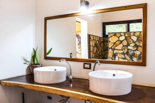 dos lavabos blancos en un mostrador con un espejo en Perfect family home in Playa Maderas, en El Plantel