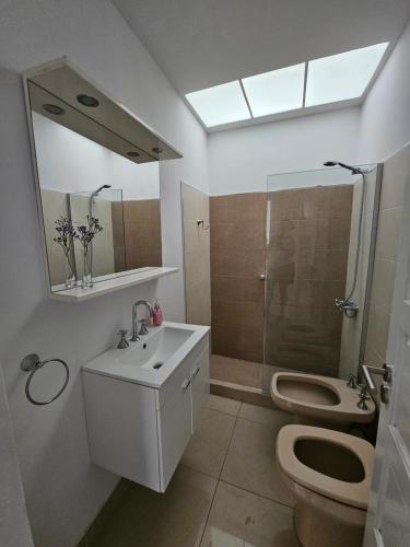 a bathroom with a toilet and a sink and a shower at Casa LH en Villa María, Córdoba in Villa María