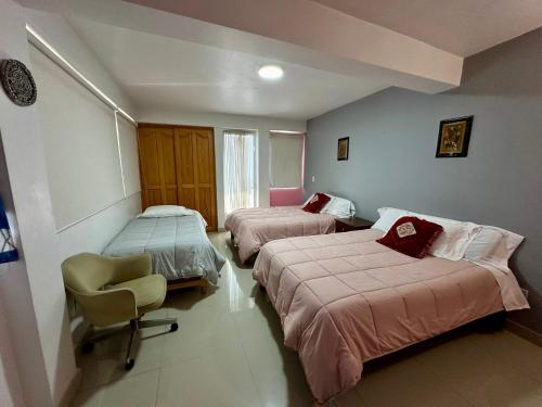 a hotel room with two beds and a chair at Huerta Don Felipe in Irimbo