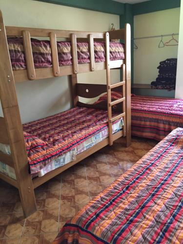 two bunk beds in a room with another bed at Hotel El Molle in Lunahuaná