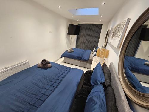 a bedroom with two beds and a mirror at Hot tub hideaway in Manchester