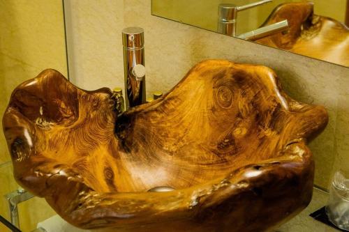 a wooden bowl shaped sink in a bathroom at Masía Durbá Hotel in Castellnovo