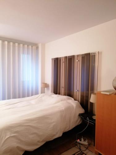 une chambre avec un grand lit blanc et une fenêtre dans l'établissement Lovely flat on the seine river, à Paris