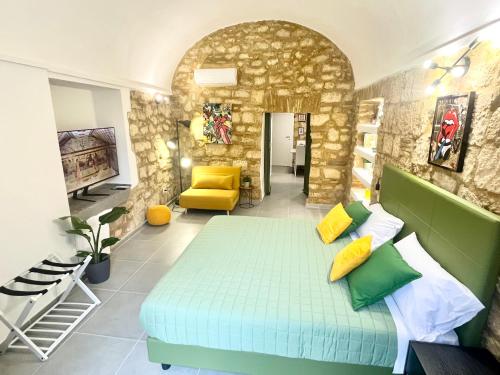 ein Schlafzimmer mit einem Bett und einer Steinmauer in der Unterkunft Casa Soderini in Tarquinia