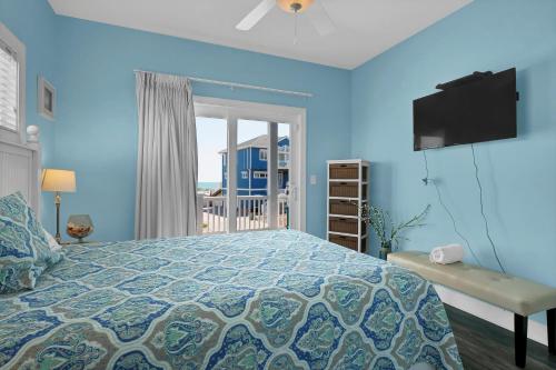 1 dormitorio azul con 1 cama y balcón en Knee Deep, en North Topsail Beach