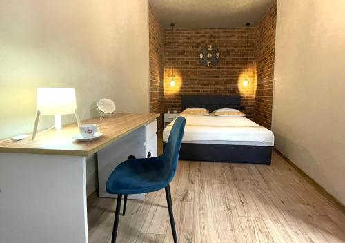 een slaapkamer met een bed, een bureau en een stoel bij Апартаменти в центрі з двома ізольованими спальнями,вул Замарстинівська in Lviv