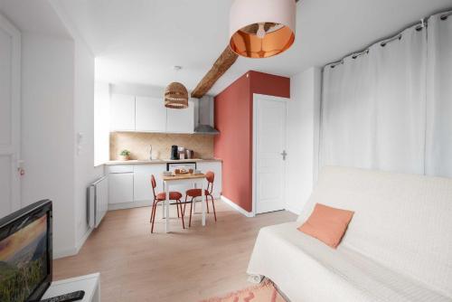 un salon avec une table et une cuisine dans l'établissement Agréable studio cosy entièrement rénové, à Mazamet