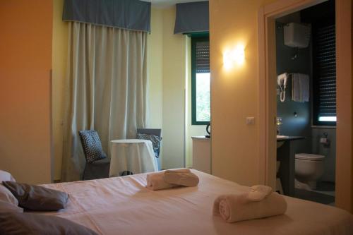 a bedroom with a bed with two towels on it at Capodichino International Hotel in Naples