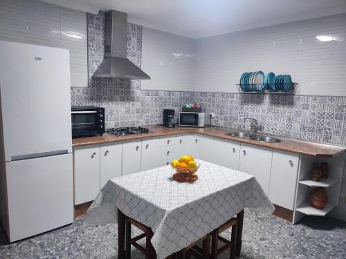 a kitchen with a table with a bowl of fruit on it at La casita del sillero in Jimena de la Frontera