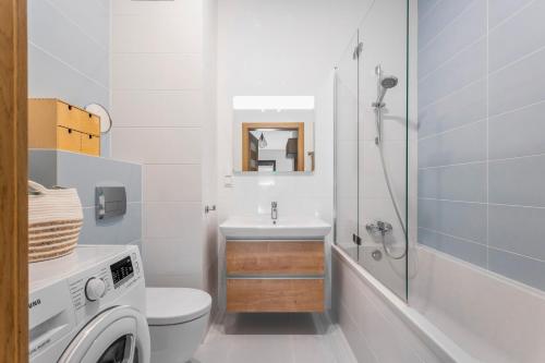 ein Badezimmer mit einem Waschbecken und einer Waschmaschine in der Unterkunft Gandalf House in Warschau