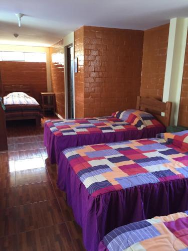 a room with two beds in a room at Hotel El Molle in Lunahuaná