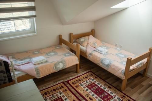 two beds in a small room with a rug at Apartments Bašić in Visoko