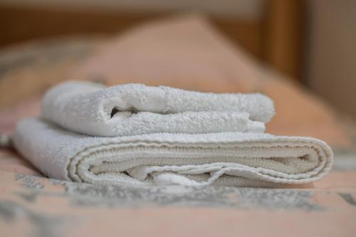 una pila de toallas blancas sentadas en una cama en Apartments Bašić, en Visoko