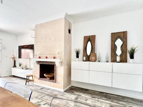 a living room with a fireplace and white cabinets at Casaabel in Badia Gran
