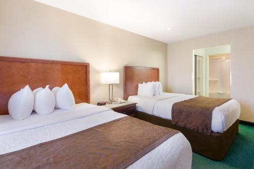 a hotel room with two beds and a lamp at MainStay Suites Roanoke Airport in Roanoke