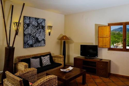 a living room with a couch and a tv at Masía Durbá Hotel in Castellnovo