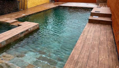 - une piscine avec une terrasse en bois et de l'eau dans l'établissement CASA MARIA, à Murcie
