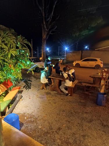 um grupo de pessoas sentadas numa mesa de piquenique à noite em Consertamos Disco Voador em Alto Paraíso de Goiás