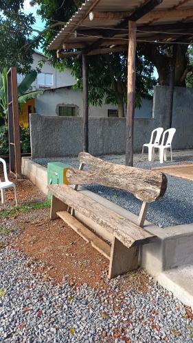 um banco de madeira sentado no chão ao lado de cadeiras em Consertamos Disco Voador em Alto Paraíso de Goiás
