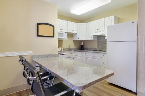 a kitchen with white cabinets and a white refrigerator at MainStay Suites Roanoke Airport in Roanoke
