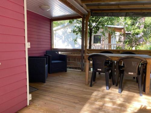 un patio avec une table et des chaises sur une terrasse dans l'établissement Campsitechalet France at Cotes d'Azur nearby sea, à Roquebrune-sur Argens