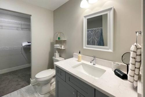 ein Badezimmer mit einem Waschbecken, einem WC und einem Spiegel in der Unterkunft New Beautiful 3 Bedroom Condo in Bettendorf in Bettendorf