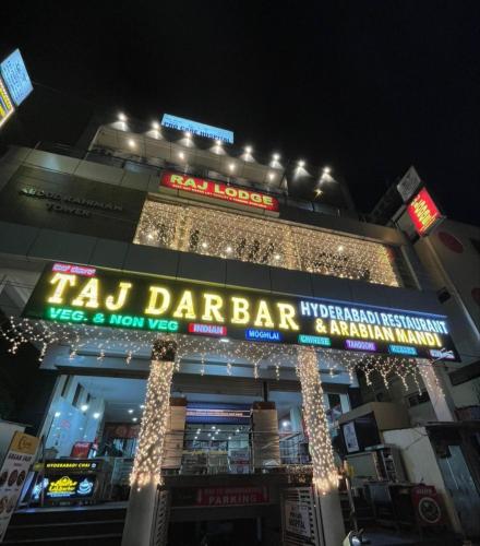 a building with a sign for a taco dance bar at night at Taj lodge in Belgaum